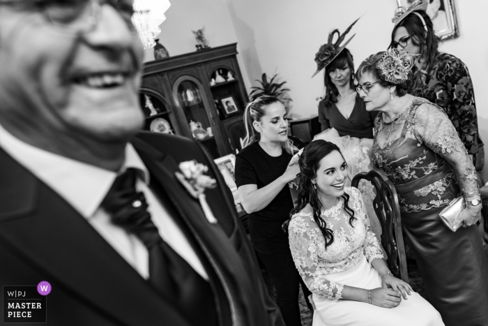 Fotografía de boda de una novia preparándose con la familia en Toledo, España