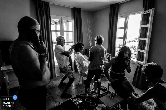 Foto por: <a href="https://www.wpja.com/contests/2018-v20/best-wedding-photographers/2404211"> Florent Cattelain - Labarthe-sur-Lèze </a> Occitanie preparando la imagen de la novia haciéndose el cabello | fotografía de boda en blanco y negro