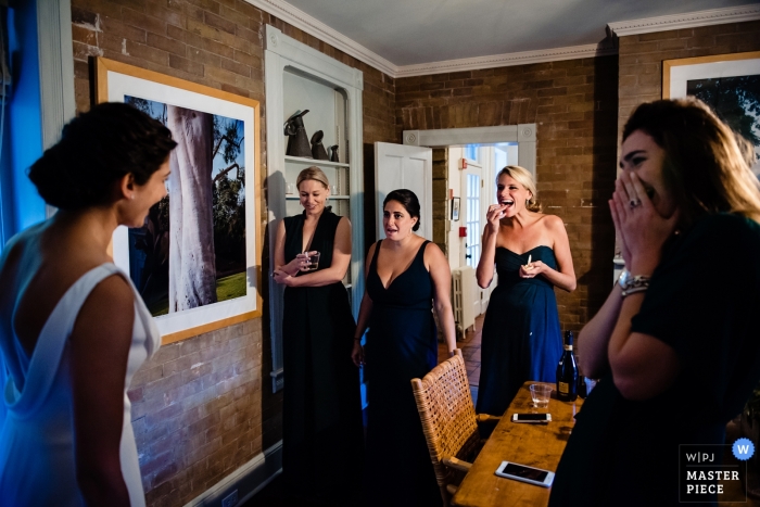 Foto di: <a href="https://www.wpja.com/contests/2018-v20/best-wedding-photographers/2408241"> Megan Hannah - Lincoln Vermont </a> Lenox, fotografo di matrimoni del Massachusetts | prima della cerimonia con la sposa che condivide l'abito con le sue damigelle