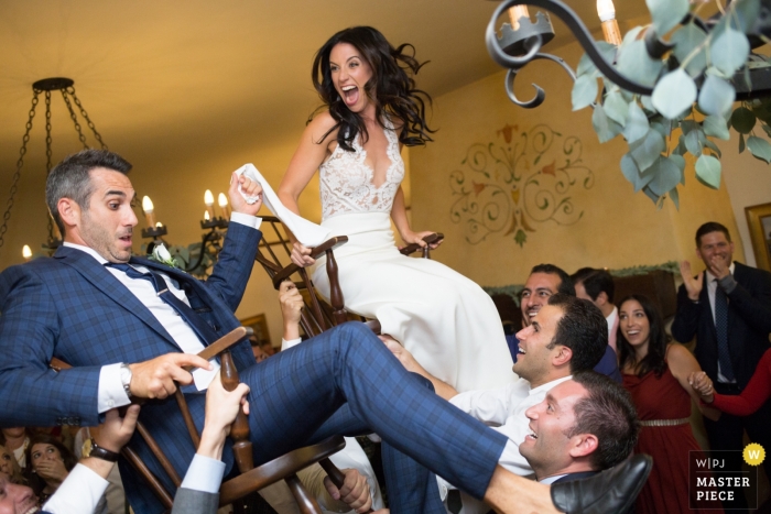 Foto por: <a href="https://www.wpja.com/contests/2018-v20/best-wedding-photographers/2410926"> Douglas Despres - Alameda California </a> Una pareja es lanzada en sillas en la fiesta de su boda en Santa Bárbara, California.