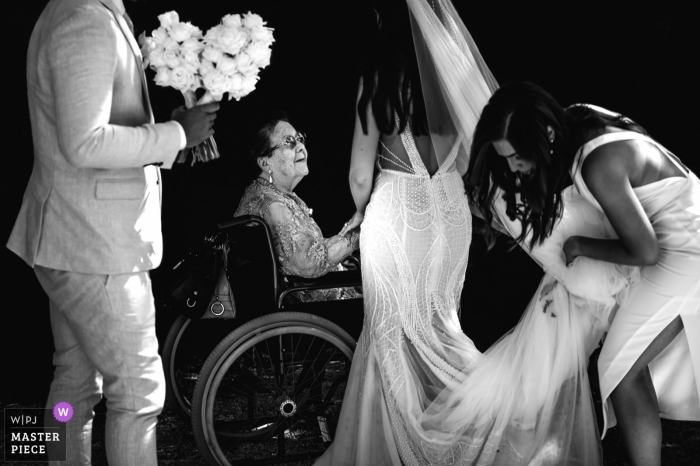 Foto von: <a href="https://www.wpja.com/contests/2019-v01/best-wedding-photographers/2422611"> Gaelle Le Berre - Mount Waverley Victoria </a> Mont Du Soleil, Hochzeitsphotographie Kalista, Australien der Brautholding und der Hand einer Frau, die in ihrem Rollstuhl gesetzt wird