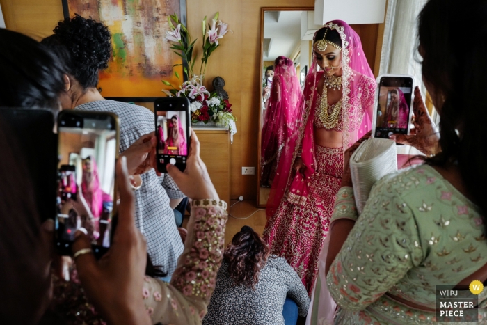 Foto por: <a href="https://www.wpja.com/contests/2019-v01/best-wedding-photographers/2429726"> William Lambelet - Montpellier </a> Mumbai, India fotografía de boda - muchos dispositivos móviles durante la preparación de la novia