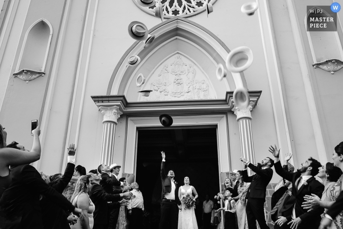 Photo by: <a href="https://www.wpja.com/contests/2019-v01/best-wedding-photographers/2431031">Vinicius Terror - Ouro Preto Minas Gerais</a> Igreja N. S. Fátima Patos de Minas Church ceremony celebration with hats being thrown into the air