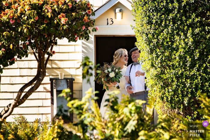 Photo by: <a href="https://www.wpja.com/contests/2019-v01/best-wedding-photographers/2433881">Joyce Perlman - San Francisco California</a> MacCallum House, Mendocino outdoor ceremony - the bride and father of the bride ceremony walk through lush trees
