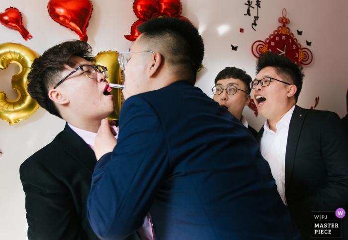 Photo by: <a href="https://www.wpja.com/contests/2019-v01/best-wedding-photographers/2434311">Yifan Liu - Binhai New Area </a> TianJin Mischief lipstick for these groomsmen during the door games in China