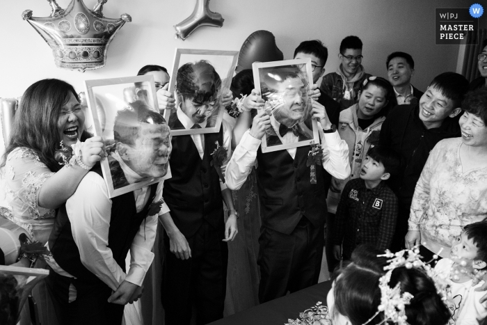 Photo by: <a href="https://www.wpja.com/contests/2019-v01/best-wedding-photographers/2435231">Vincent Mu - De Zhou </a> China Reception Game for the groomsmen - faces smashing through clear plastic wraped on frames