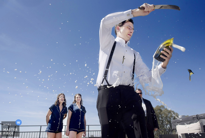 Foto door: <a href="https://www.wpja.com/contests/2019-v01/best-wedding-fotografen/2435306"> Laura Segall - Phoenix Arizona </a> Phoenix, AZ Champagnezwaard - de bruidegom opent de fles buitenshuis