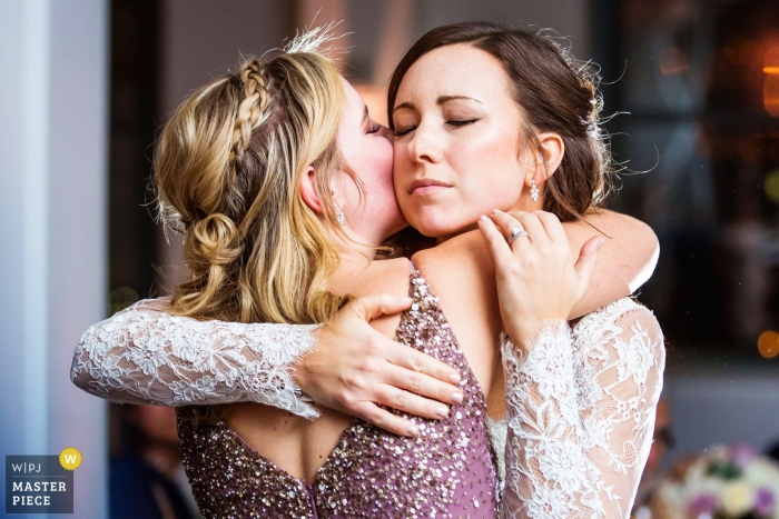 Bride has emotional hug from sister of the bride after toasts at Tribeca 360 NYC wedding 