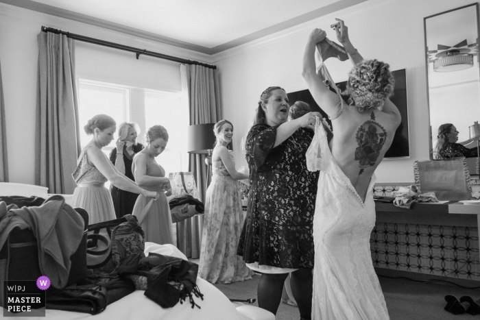 Photo by: <a href="https://www.wpja.com/contests/2019-v01/best-wedding-photographers/2437736">Annie Bang - Los Angeles California</a> Santa Barbara, California wedding photo - The bride gets help from her family and friends as she puts her wedding dress on.