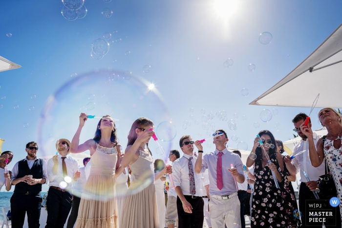 Photo by: <a href="https://www.wpja.com/contests/2019-v01/best-wedding-photographers/2438521">Julie Ambos - Key West Florida</a> Key West wedding photo of Guests Prepping for a bubble exit after the outdoor ceremony