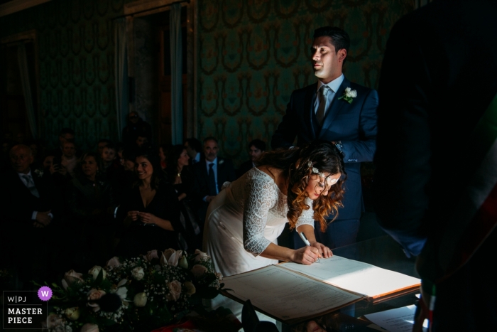 Fotografía de bodas de Siracusa: la novia y el novio ponen sus firmas en el certificado de matrimonio