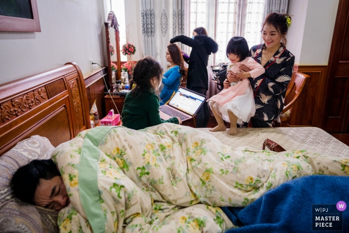 Foto door: <a href="https://www.wpja.com/contests/2019-v02/best-wedding-fotografen/2443321"> Nam Le - Ho Chi Minh </a> Ho Chi Minh-huwelijksfoto's - Voorbereidingen treffen met kinderen en een man die op het bed slaapt