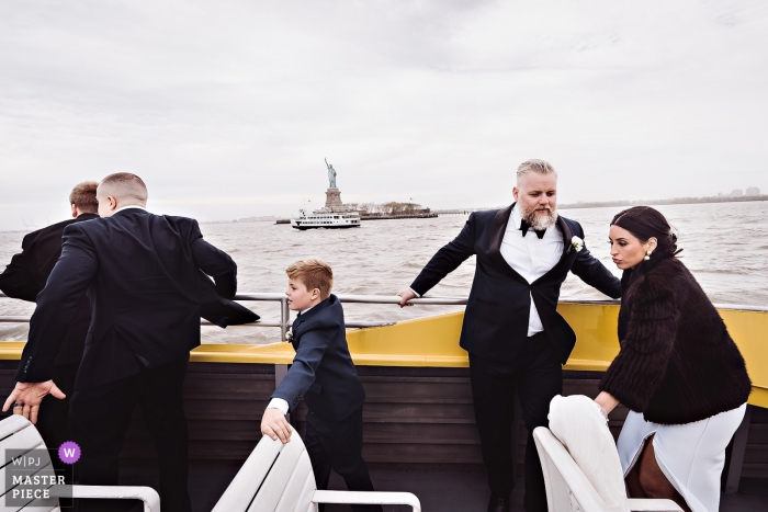 La foto de la boda de Liberty Warehouse, NY captó a los invitados, la novia y el novio tratando de no perder el equilibrio en un bote The Liberty Warehouse, NY barcos de boda - fotógrafo atrapado Invitados, la novia y el novio tratando de no perder el equilibrio en el watertaxi