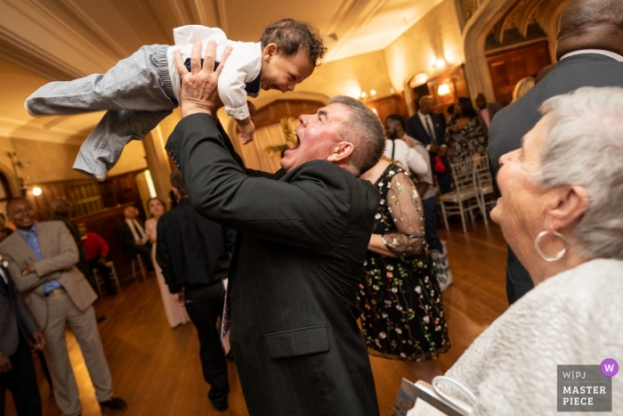 Foto: <a href="https://www.wpja.com/contests/2019-v02/best-wedding-photographers/2447106"> Joshua Grasso - Buford Georgia </a> Atlanta Georgia Hochzeitsfotografie - kleiner Junge wird auf der Tanzfläche gehoben