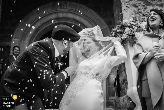 Fotografia di matrimonio di Alicante - la sposa e lo sposo si riempiono di coriandoli mentre lasciano la cerimonia della chiesa