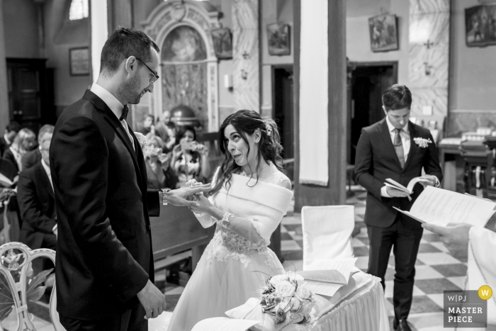 wedding ceremony photography Chiesa provincia lecco | the bride places the ring on the grooms finger during the ceremony