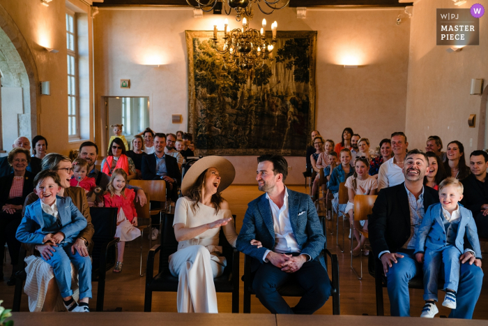 Photo by: <a href="https://www.wpja.com/contests/2019-v03/best-wedding-photographers/2458951">Yves Schepers - Bonheiden Antwerpen</a> City hall of Zomergem wedding photograph showing Laughs from the bride and groom and guests during civil wedding
