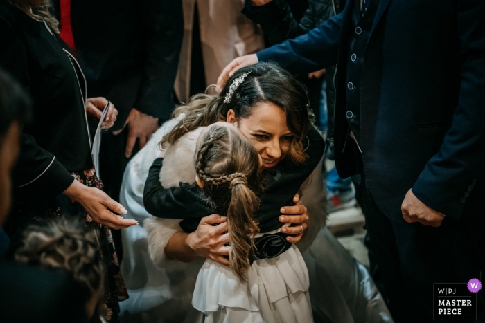 San Giovanni Battista (Giulianello LT) photographie de mariage | la mariée heureuse embrasse une jeune fille