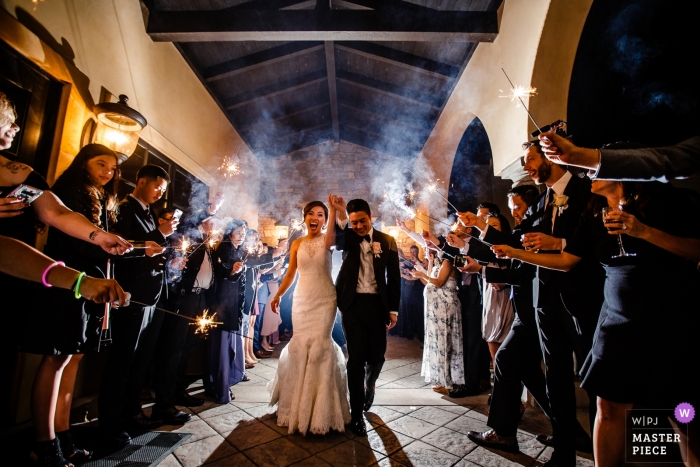 Photo by: <a href="https://www.wpja.com/contests/2019-v04/best-wedding-photographers/2462561">Raymond Nguyen - Sacramento California</a> Photo of the bride and groom exiting and walking through guests who hold sparklers by a Lake Tahoe, CA wedding photographer.