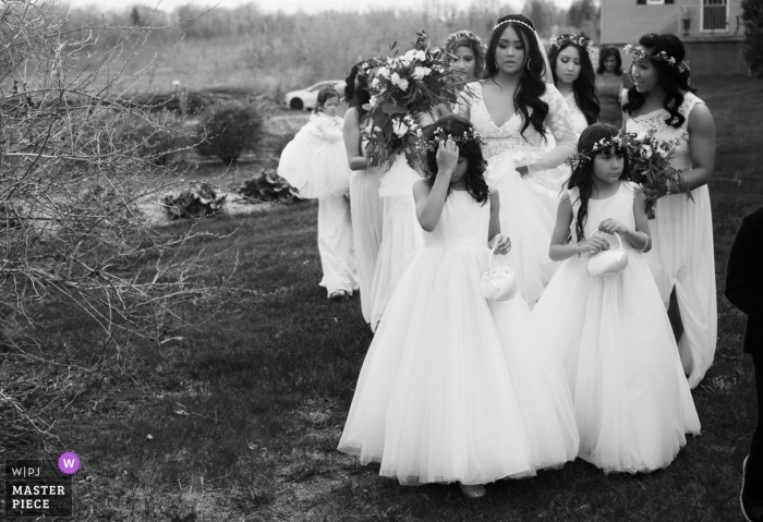Photo by: <a href="https://www.wpja.com/contests/2019-v04/best-wedding-photographers/2463151">Kathi Robertson - Ottawa Ontario</a> Black and White photograph of the bride with her bridesmaids and flower girls walking to the ceremoy site at Strathmere Ottawa Canada
