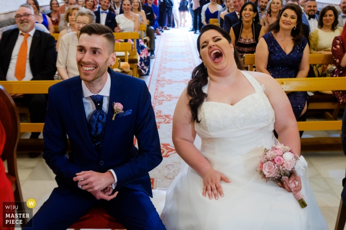 Photo by: <a href="https://www.wpja.com/contests/2019-v04/best-wedding-photographers/2465811">Toni Miranda - Alcoy Alicante</a> The bride and groom smile and laugh as they sit at the altar in Santa Pola in this photo by an Alicante, Valencia wedding photographer.