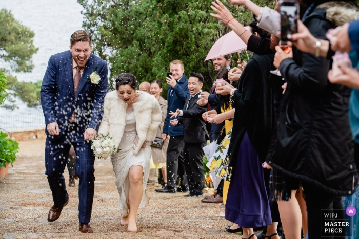 Photo of rice throwing at the bride and groom after the ceremony at El Convento de Blanes