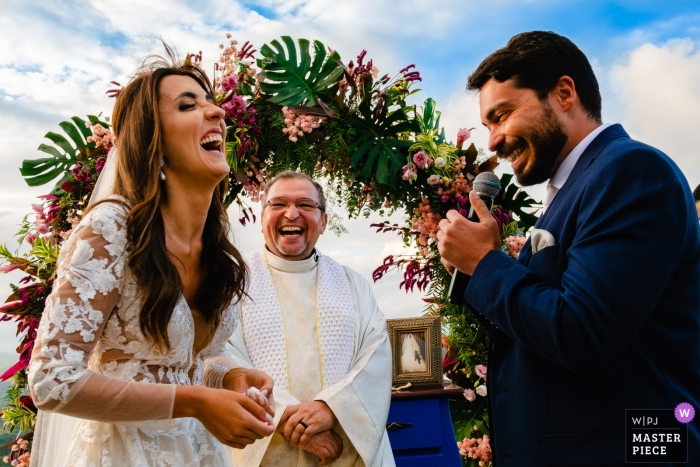 Photo by: <a href="https://www.wpja.com/contests/2019-v04/best-wedding-photographers/2466681">Vinicius Terror - Ouro Preto Minas Gerais</a> The bride and groom laugh at the altar during their outdoor ceremony at Vila Relicario in this photo by a Brazil wedding photographer.