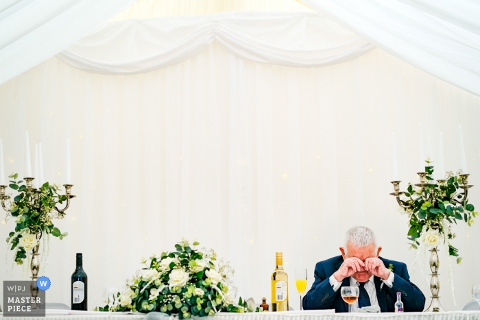 Der Großvater der Braut nimmt sich während des Hochzeitsempfangs bei einer Hochzeit in Southampton, Großbritannien, einen Moment Zeit