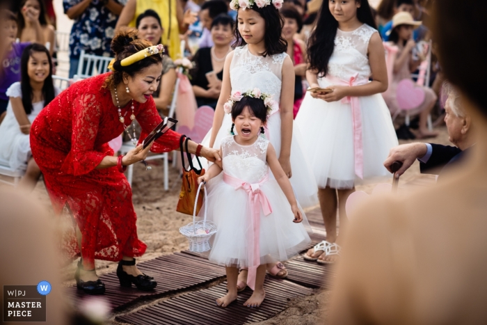 Photo by: <a href="https://www.wpja.com/contests/2019-v04/best-wedding-photographers/2467561">Huy Nguyen - Ho Chi Minh </a> Phu Quoc Ho Coc Outdoor Wedding Ceremony photo of young flower girl crying.