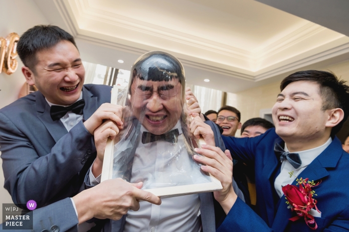 Photo by: <a href="https://www.wpja.com/contests/2019-v04/best-wedding-photographers/2468111">Cen Lin - Fuzhou </a> The best man plays a game with the other groomsmen in the living room of a Fuzhou home in this photo by a China wedding photographer.