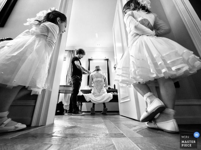 Foto en blanco y negro de la novia preparándose mientras dos niñas miran en Villa Necchi, Gambolò - Italia