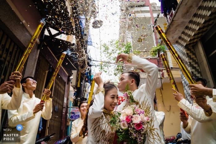 Photo by: <a href="https://www.wpja.com/contests/2019-v04/best-wedding-photographers/2470196">Vu Nguyen - Ho Chi Minh </a> Photo of the bride and groom at the Groom House in Saigon as the groomsmen fire confetti cannons around them by a Vietnam wedding photographer.
