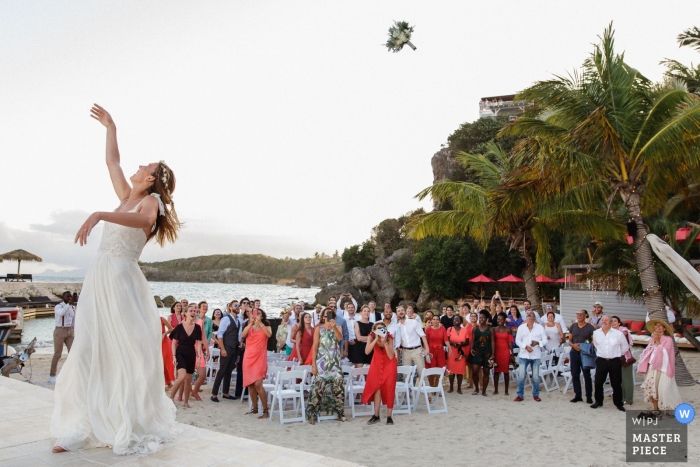 Zdjęcie: <a href="https://www.wpja.com/contests/2019-v04/best-wedding-photographers/2470901"> Jeremy Fiori - Angers </a> La Toubana - zdjęcie dnia ślubu Gwadelupy z bukietem Launched autorstwa panny młodej na plaży