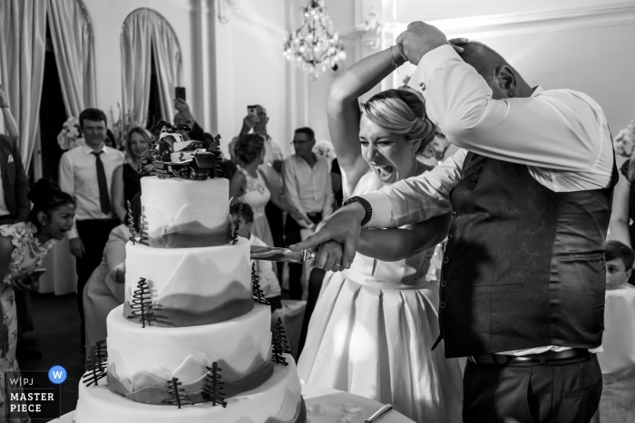 LA8, Baden-Baden Hochzeitsfoto der Braut und des Bräutigams Kämpfe, um die Kontrolle zu bekommen, um den Kuchen zu schneiden