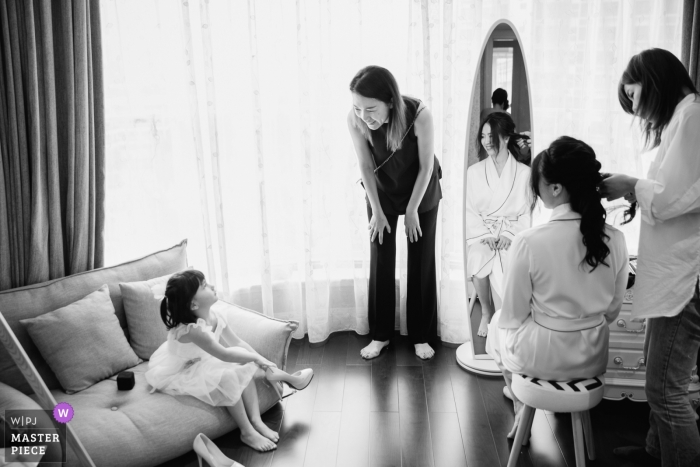 Photo by: <a href="https://www.wpja.com/contests/2019-v05/best-wedding-photographers/2476906">Leon Wong - Hangzhou </a> Guangzhou, China Actual Day Wedding Photography - When the bride puts on makeup, a kid tries to put on the bride's wedding shoes, which triggers the laughter of her mom and bride.