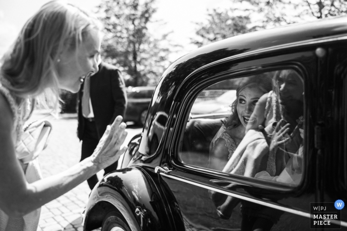 Bangkok wedding photographer captured this black and white photo of the bride getting her dress steamed before the ceremony Elisabethen Kirche Marburg and Hofgut Dagobertshausen - Photo of the bride's Arrival at the location