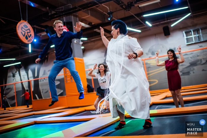 Hochzeitsfotografie der Braut und des Bräutigams, die in der Trampolinzone springen – Niagara, Sofia, Bulgarien