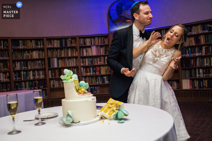 Photo by: <a href="https://www.wpja.com/contests/2019-v05/best-wedding-photographers/2480581">Annie Bang - Los Angeles California</a> Photo of the groom and the bride enjoying the moment right after cake cutting and aggressively feeding each other at the American Jewish University-Brandeis Bardin Campus, Brandeis, CA