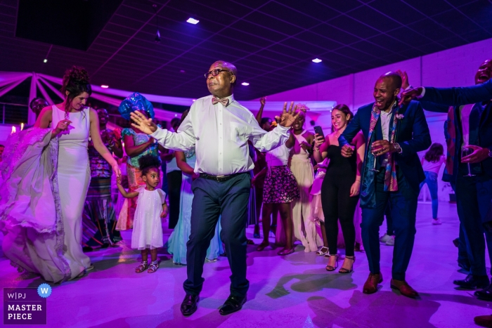 Photo by: <a href="https://www.wpja.com/contests/2019-v05/best-wedding-photographers/2481181">Henri Deroche - Orléans </a> Chartres Wedding Reception Photography - Image of the dancing Grandfather on Fire under purple lighting