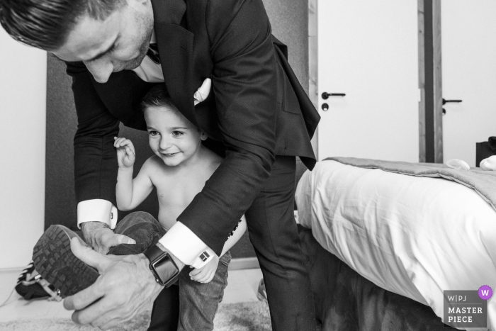 Photo by: <a href="https://www.wpja.com/contests/2019-v05/best-wedding-photographers/2481766">Sylvain Bouzat - Lyon </a> Wedding photo of preparations in a small room with a kid at the Chateau de Chapeau Cornu