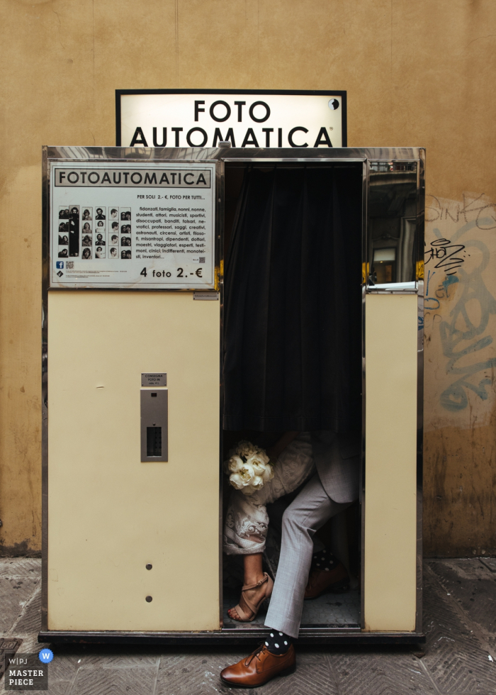 Huwelijksfoto van de bruid en de bruidegom in fotocabine bij het Hotel Grote Cavour, Florence, Italië op huwelijksdag.