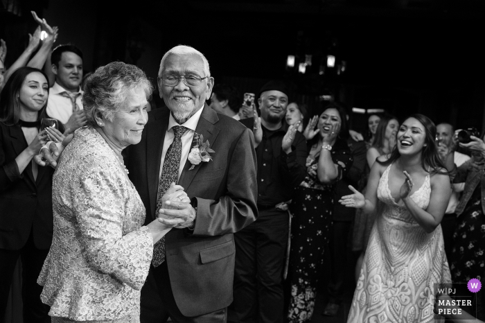 Photo: <a href="https://www.wpja.com/contests/2019-v05/best-wedding-photographers/2482561"> Tara Theilen - Carson City dans le Nevada </a> West Shore Cafe, Homewood, CA Photos de mariage - La foule célèbre les années 65 de mariage des grands-parents de la mariée lors de la danse anniversaire.