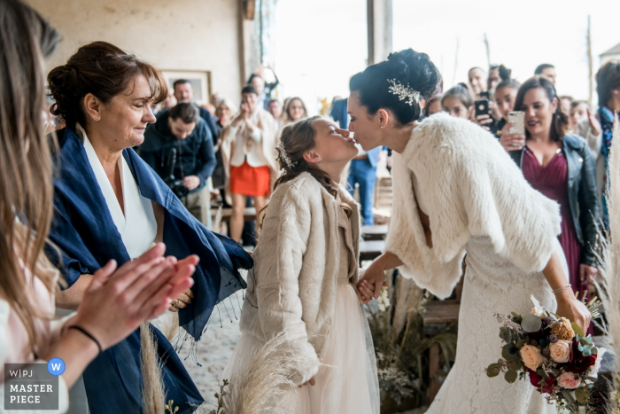 Photo de: <a href="https://www.wpja.com/contests/2019-v05/best-wedding-photographers/2482721"> Cedric Derbaise - Bury </a> Cette photo de la mariée embrassant sa fille lors de la cérémonie de mariage a été capturée par un photographe de mariage de l'Oise