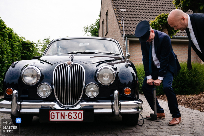 Photo by: <a href="https://www.wpja.com/contests/2019-v05/best-wedding-photographers/2483631">Yves Schepers - Bonheiden Antwerpen</a> Antwerpen Wedding Photographer captured this image of the driver of the ceremonial car has a flat tire right before the couple needs to leave