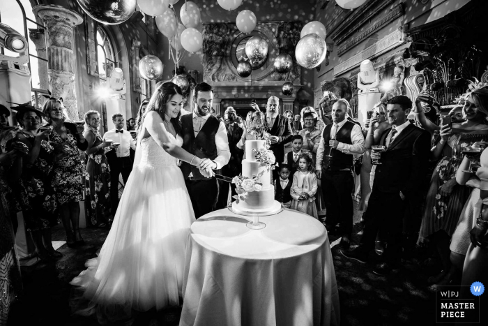 Photo by: <a href="https://www.wpja.com/contests/2019-v06/best-wedding-photographers/2486566">Aaron Storry - Kettering Northamptonshire</a> Aynhoe Park, Oxfordshire, United Kingdom wedding photography showing the bride and groom cutting the cake in the Orangery at Aynhoe Park
