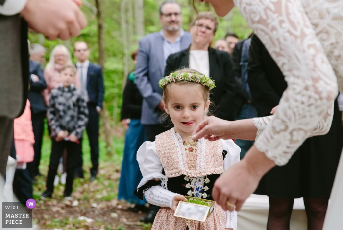 Forest, Appenzell Switzerland outdoor wedding ceremony image of young girl with rings.