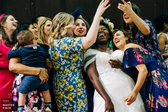 Photo by: <a href="https://www.wpja.com/contests/2019-v06/best-wedding-photographers/2492831">Wayne La - London London</a> Vestry Hall, Sutton, UK wedding day photo of the Bride having selfie photo fun with friends