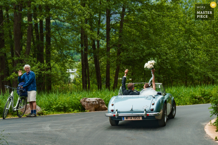 bride and groom driving away in convertible car Zell Am See, Schloss Prielau, Austria Photo of bride and groom driving away in convertible car after wedding ceremony.