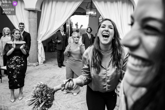 Palacio de Aldovea | Bridal bouquet throwing photograph at the wedding reception