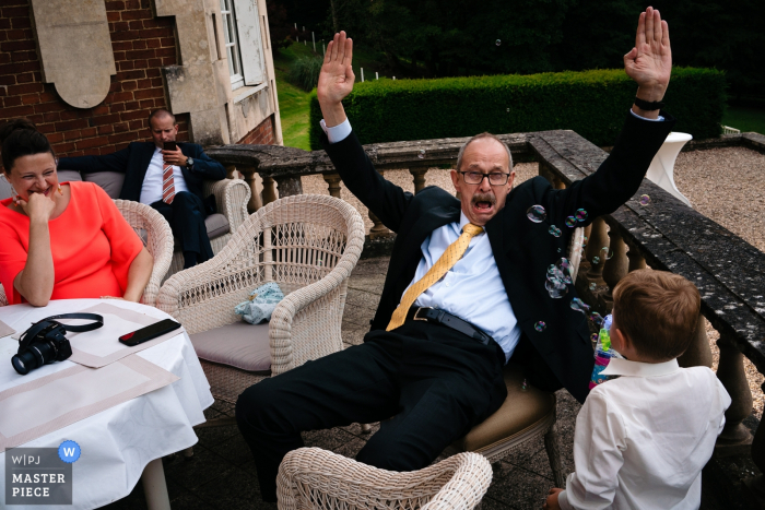 Photo by: <a href="https://www.wpja.com/contests/2019-v06/best-wedding-photographers/2493686">Yves Schepers - Bonheiden Antwerpen</a> Privately Castle Wedding Photography - Little guy uses his bubble gun to shoot wedding guest while the mom is watching and laughing
